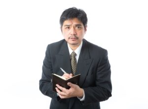 交際俱楽部のシステムをメモ帳に書き込む男性